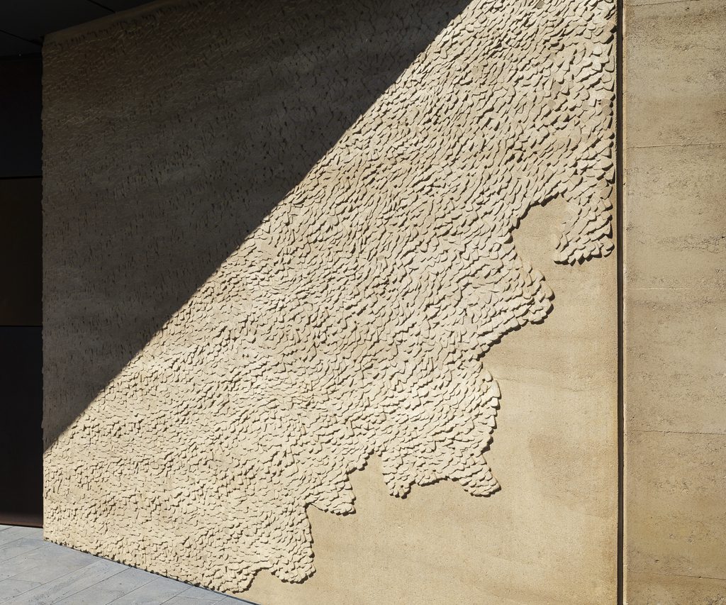 artwork as a relief on rammed earth wall