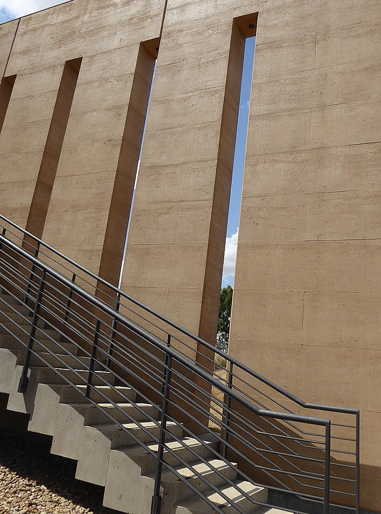 External 8m rammed earth walls with concrete stairs